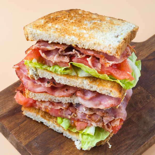 A towering Gridiron Grill & Tap House BLT sandwich with bacon, lettuce, and tomato on toasted bread.